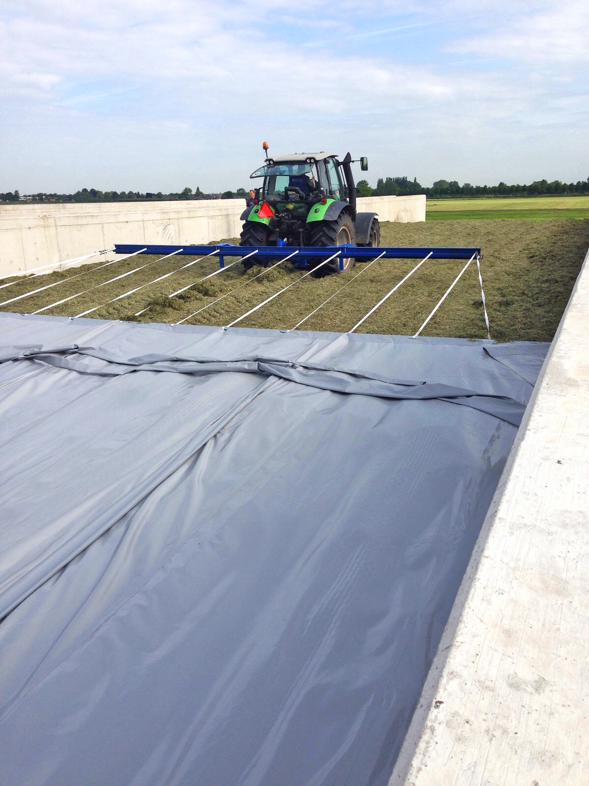 Kornet afdekkleed met tractor over het ruwvoer getrokken